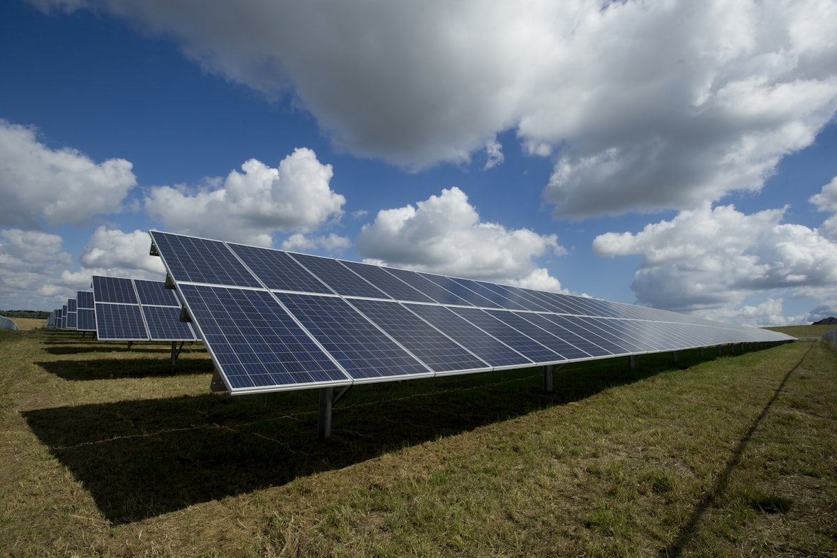 Solaranlage in Reihen auf einer Freifläche unter blauem Himmel